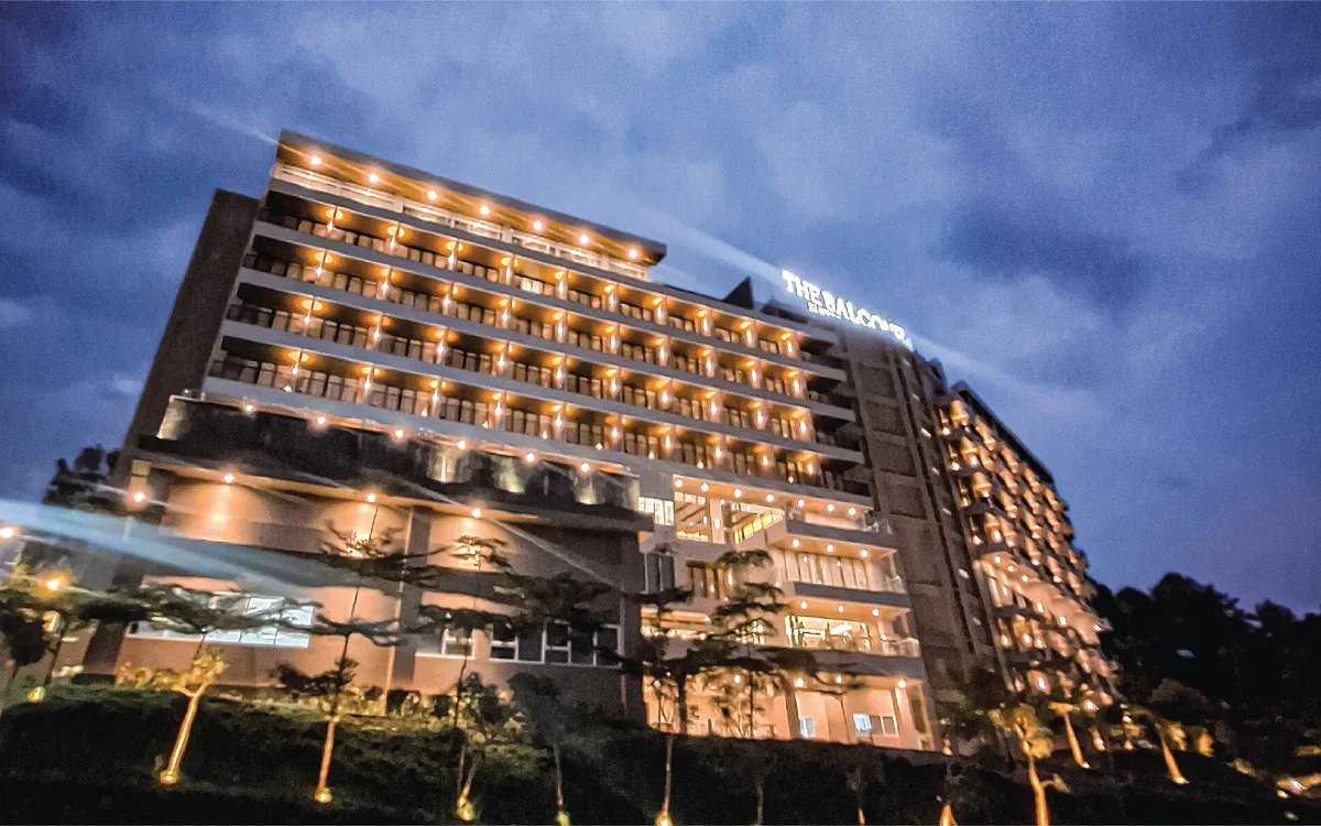 Bangunan The Balcone Suites & Resort bercahaya pada waktu senja